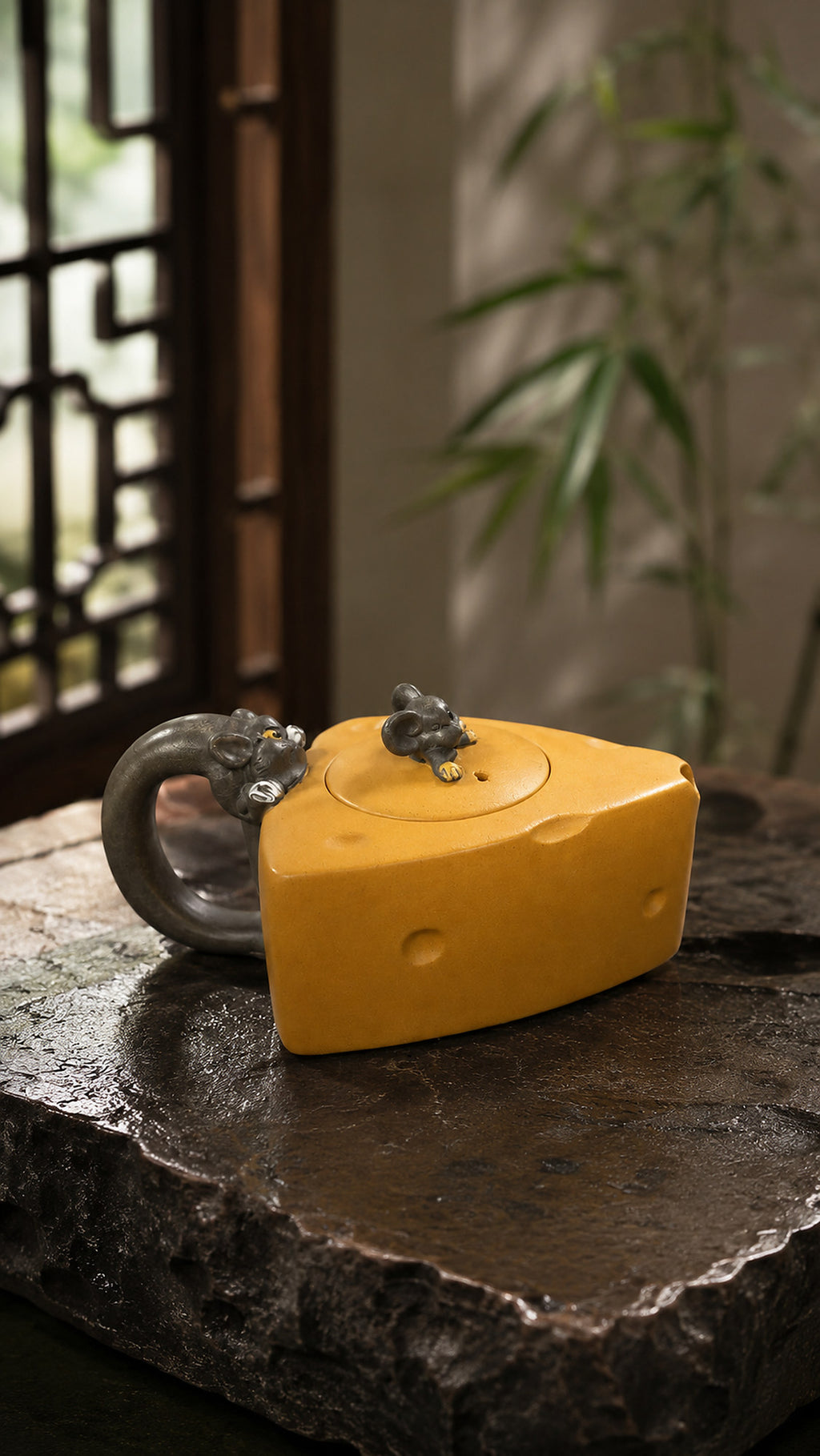 Cheese-form Yixing teapot in golden Duanni, front view on a dark stone slab
