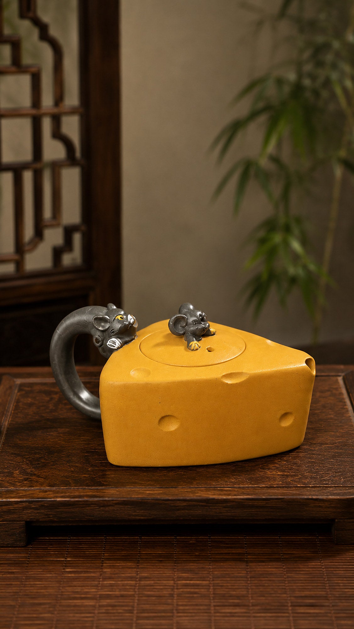 Cheese-form Yixing teapot in golden Duanni, front view on a wood tabletop