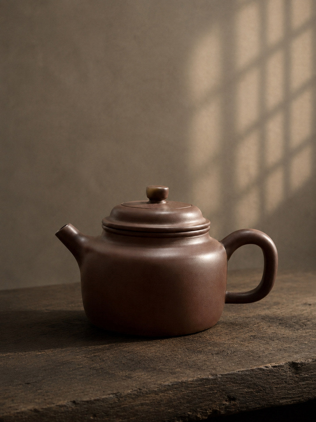 Dezhong teapot, full alternate side view on a rustic wooden table
