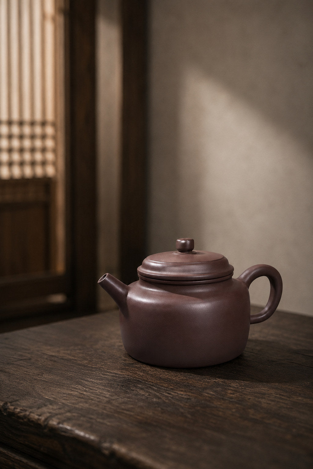 Dezhong teapot, full alternate side view beside a lattice window