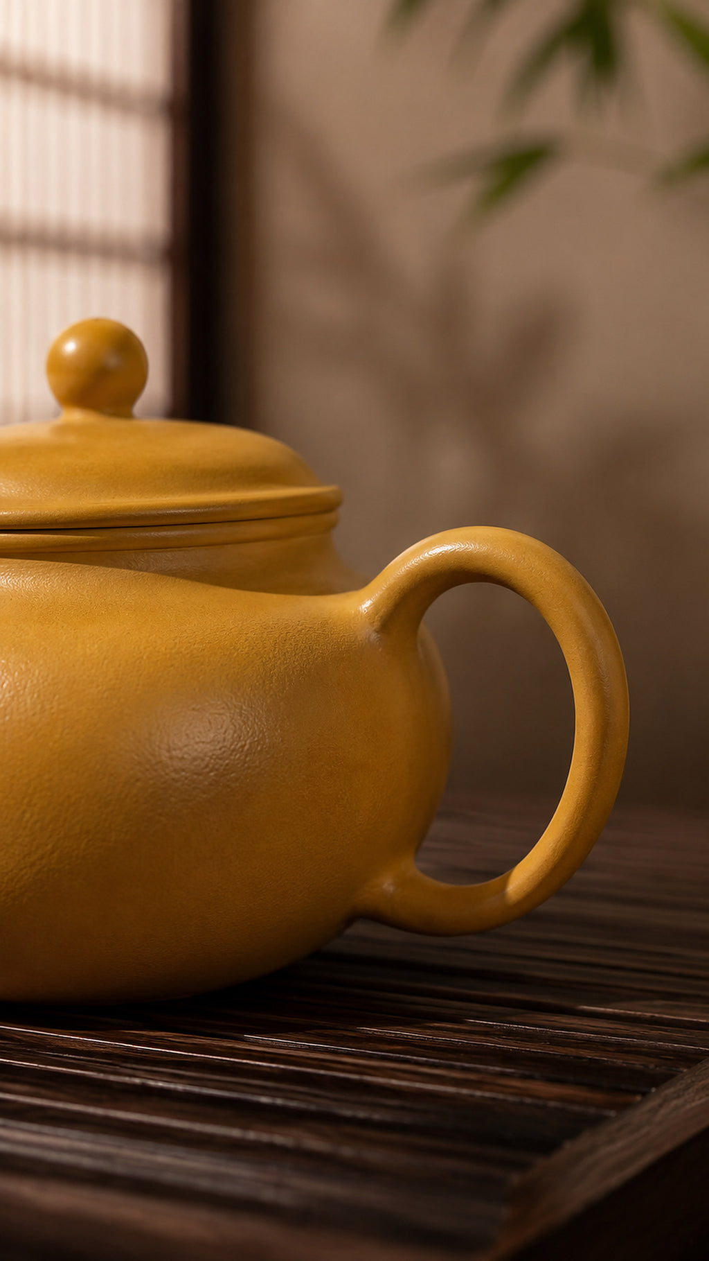 Gong Zhu Yixing teapot in golden Zhuni, close-up of loop handle and rounded body