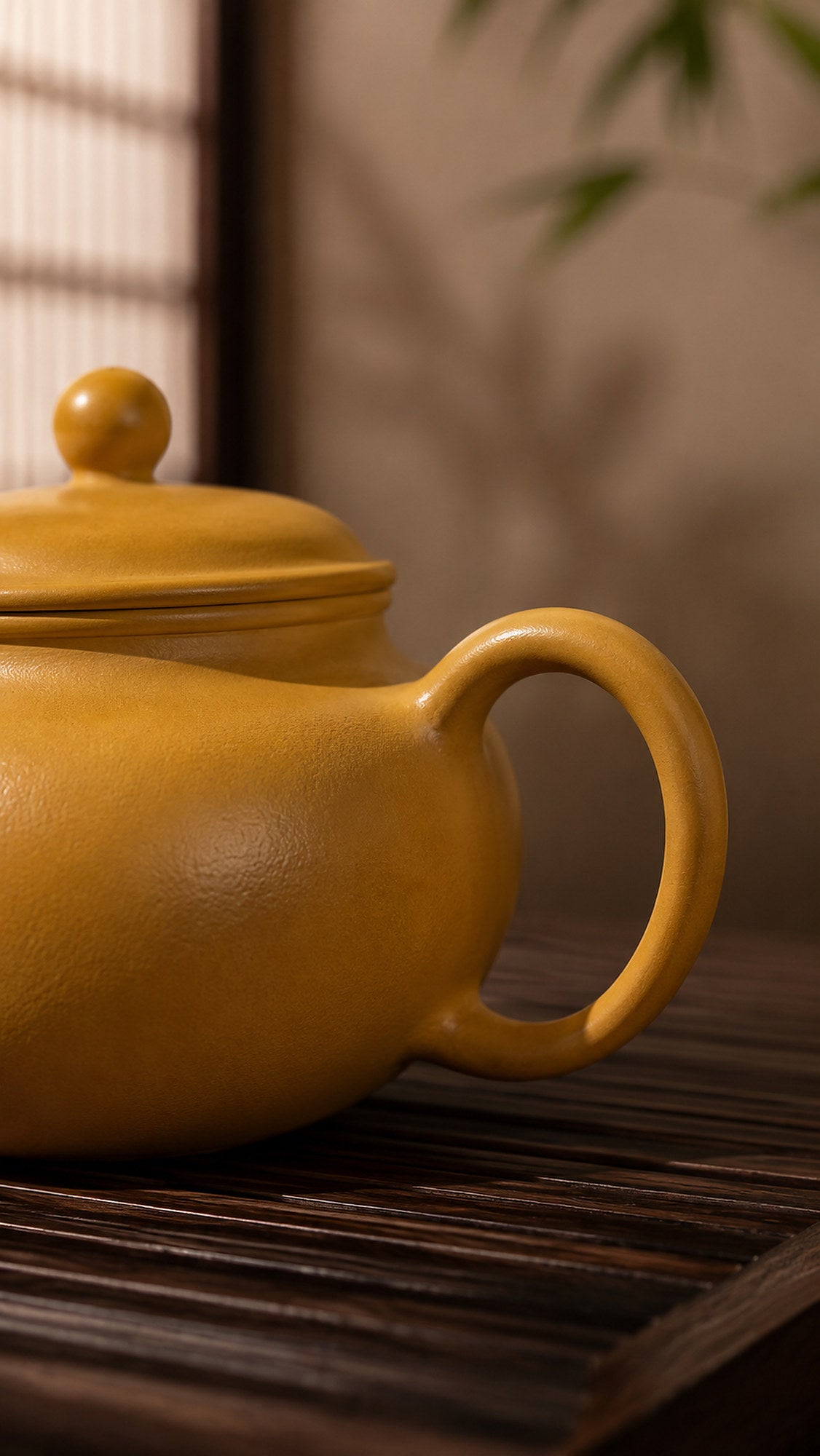 Gong Zhu Yixing teapot in golden Zhuni, close-up of loop handle and rounded body
