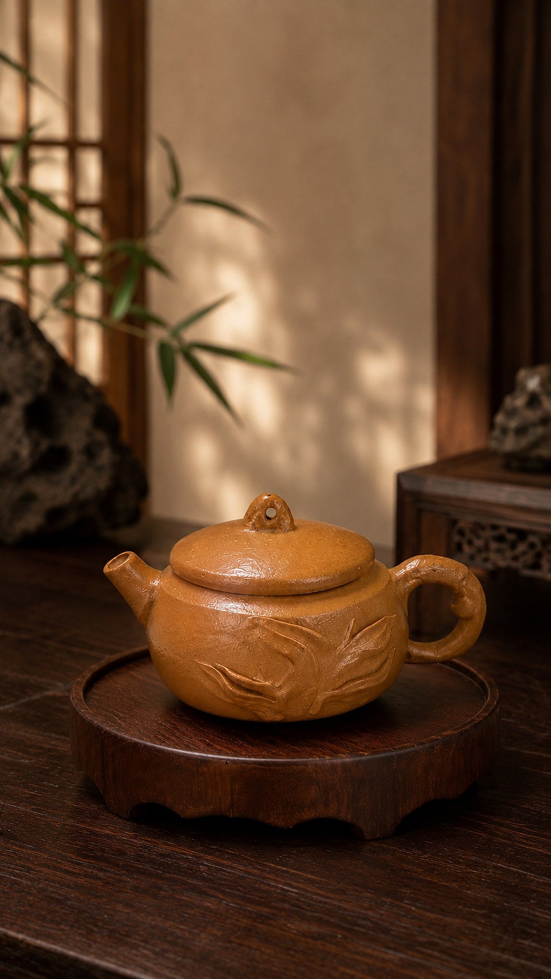 Hanwa Yixing teapot in golden Duanni, side view on a carved stand by a lattice window