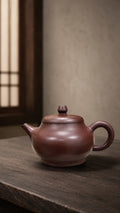 Pan Hu teapot in Zipao Yusha Clay, full side view of the rounded belly and raised foot