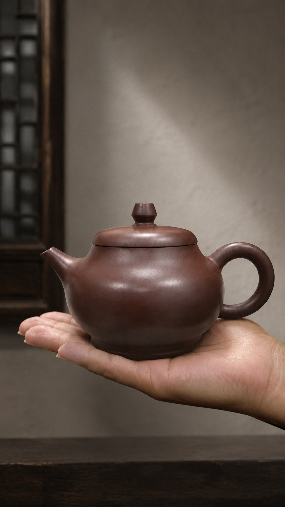 Pan Hu teapot, held on an open palm to show its compact scale