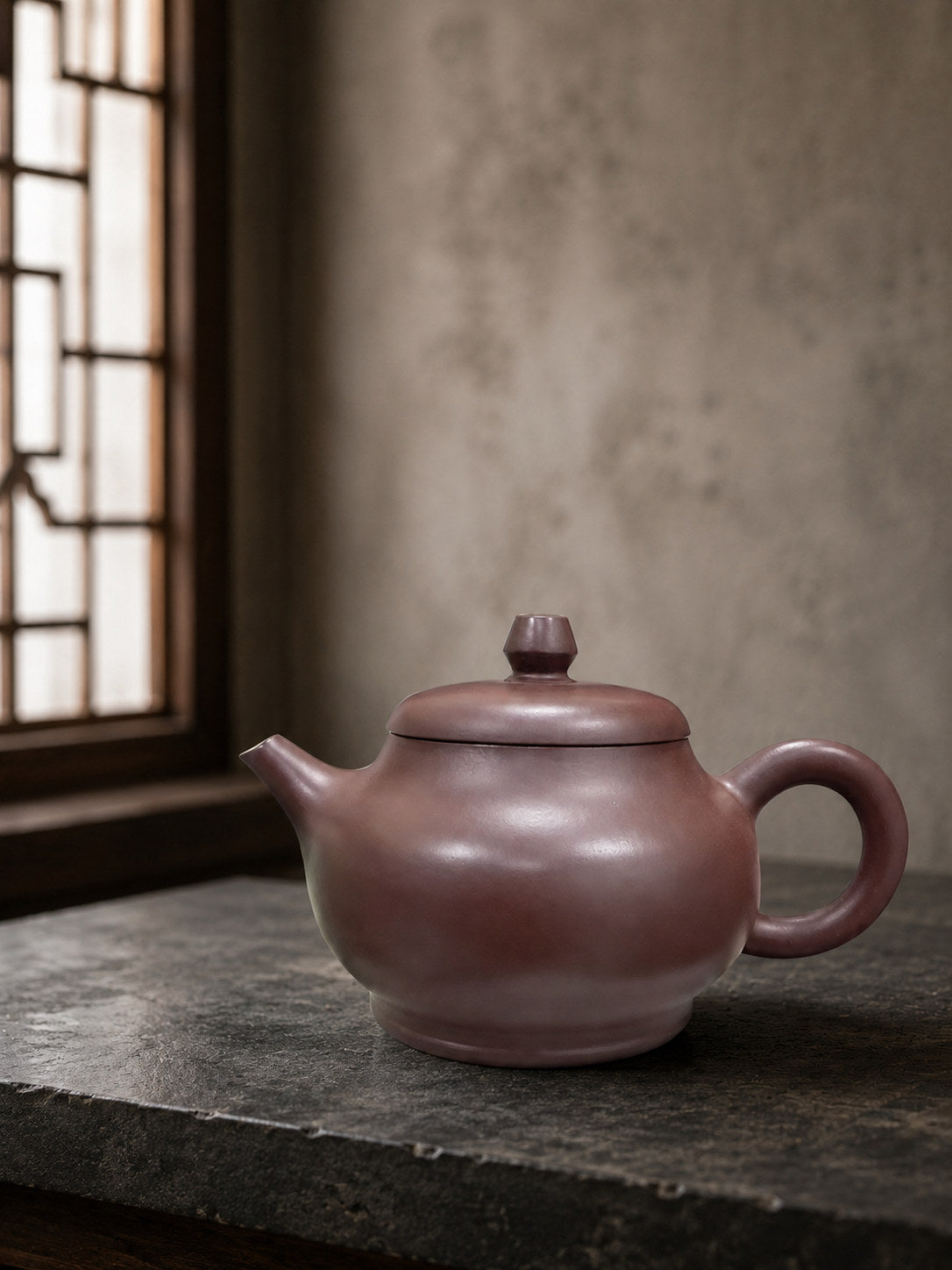 Pan Hu teapot, full side view on a stone-textured table beside a bright window