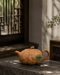 Pumpkin-form Yixing teapot in golden Duanni, left profile in a sunlit interior