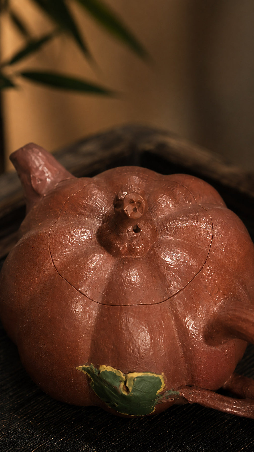 Pumpkin-form Yixing teapot in Jiangponi, close-up of stem lid and green leaf accent