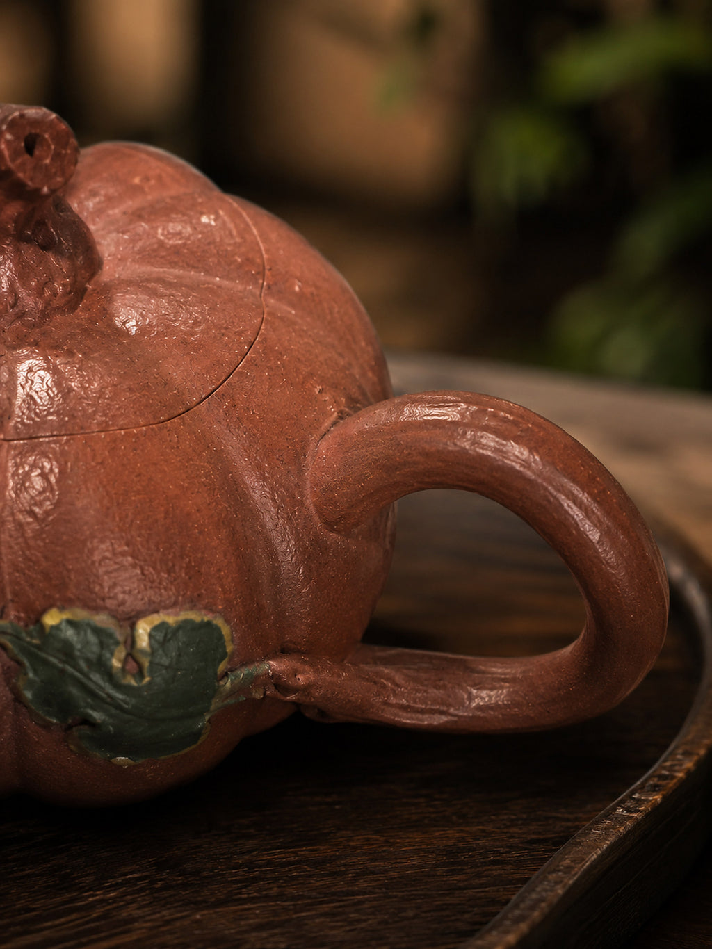 Pumpkin-form Yixing teapot in Jiangponi, close-up of loop handle and green leaf accent