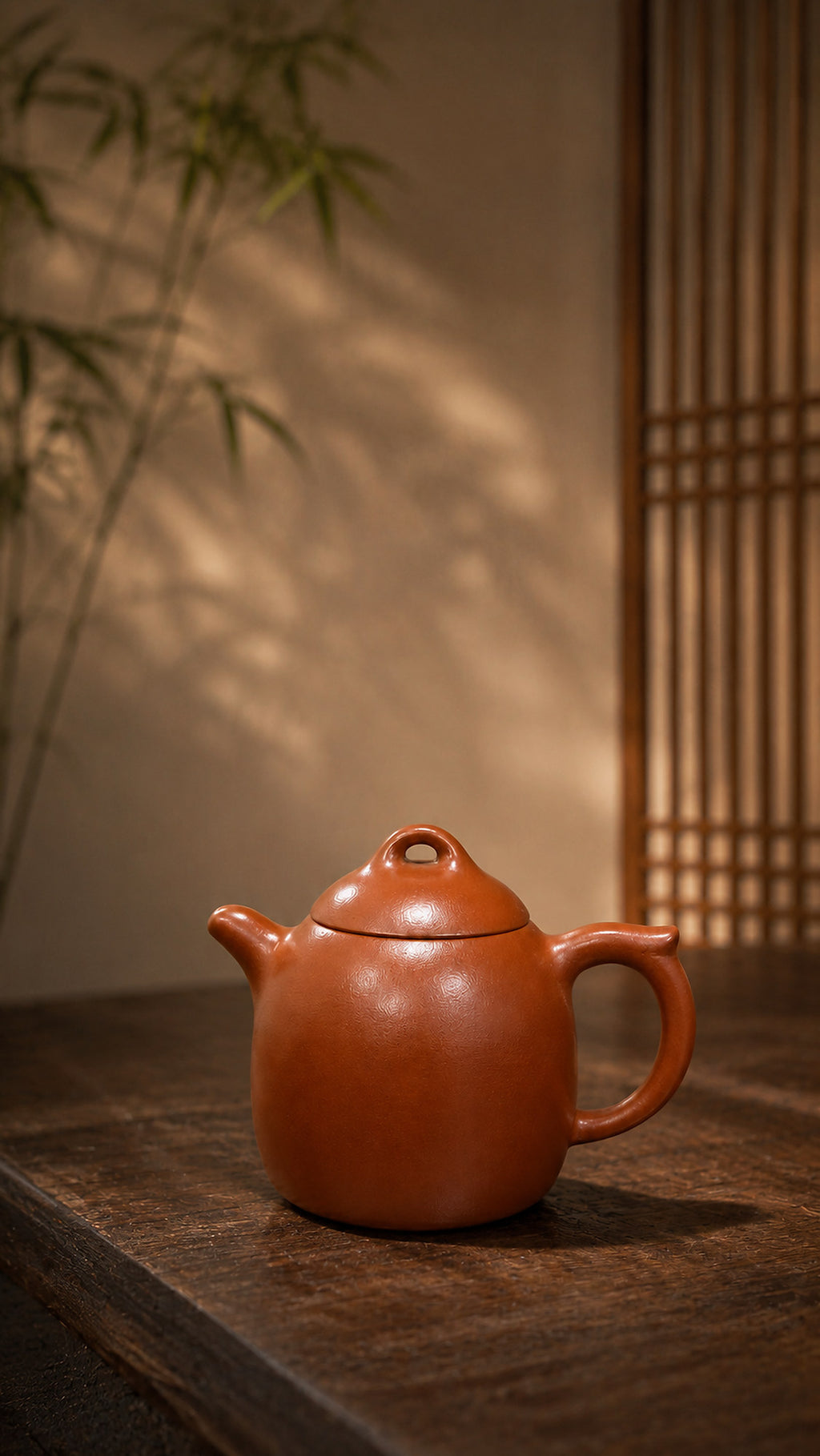 Red Jiangponi Qinquan teapot in warm bamboo-filtered light