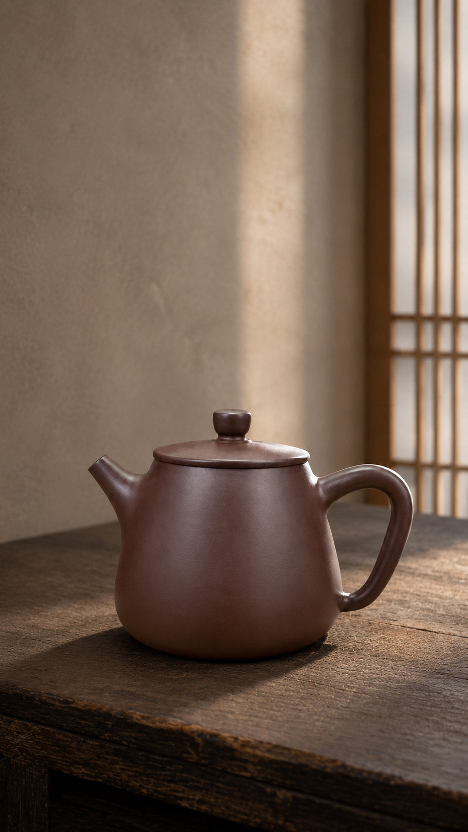 Tall Shipiao teapot, wide front-side view on a wooden table in warm window light