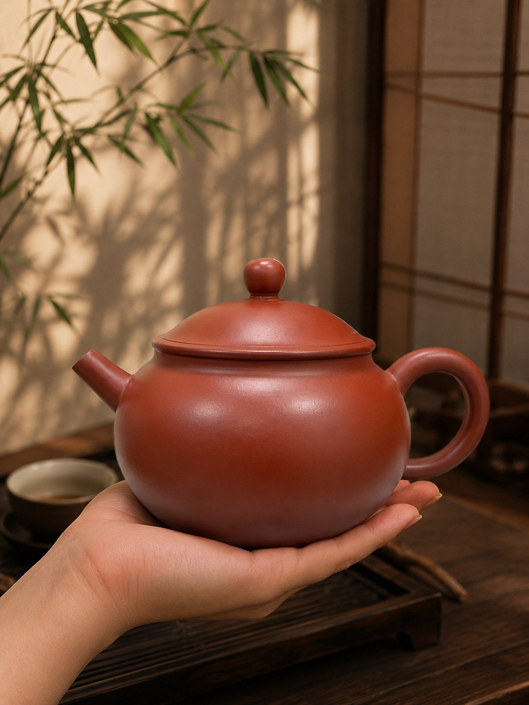Yuan Bao teapot, held on an open palm to show its compact scale