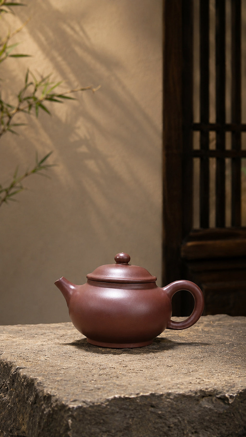 Dicaoqing Zini Yuan Bao teapot displayed on pale stone