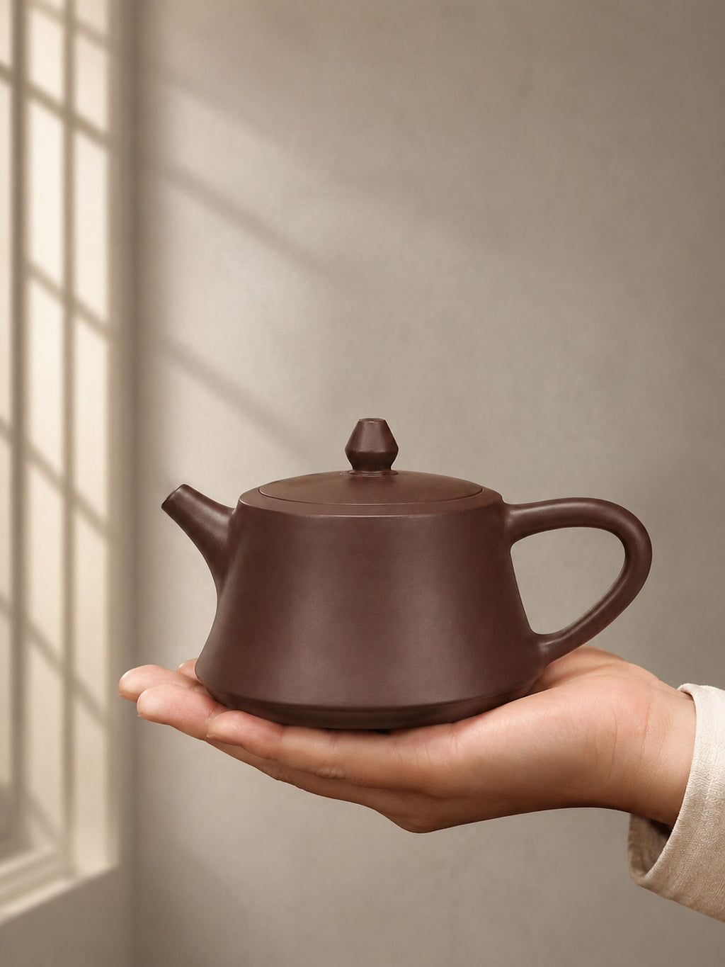 Zhu Chu teapot, held on an open palm to show its compact scale